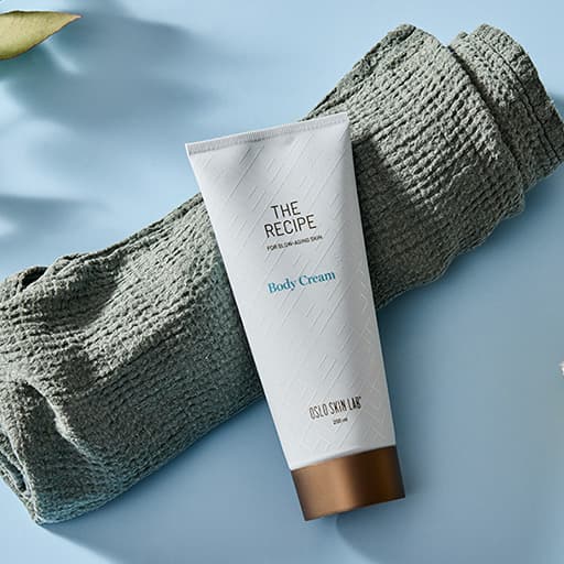 balení Body cream The Recipe položené na smotaném ručníku