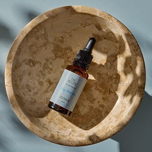 lahvička denního séra The Recipe Day Serum v dřevěné misce